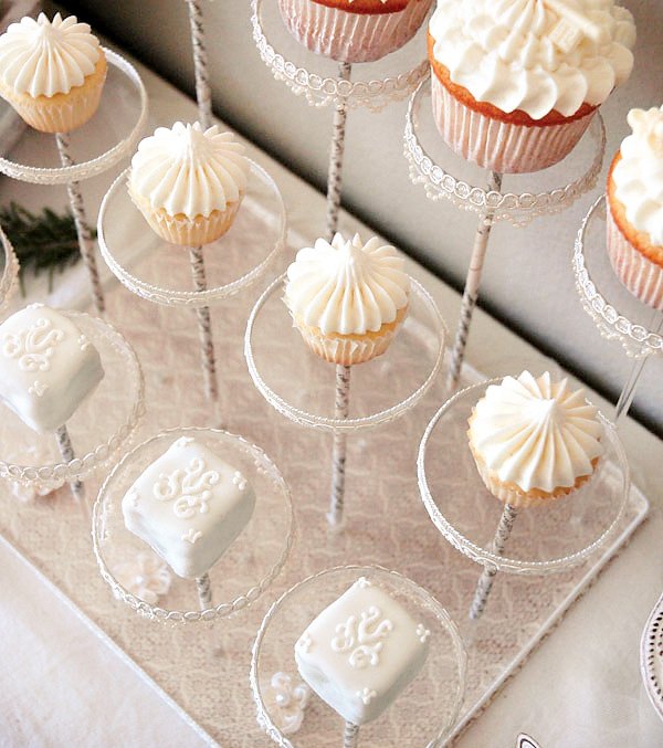 white winter cupcakes and petit fours on acrylic pastry pedestals