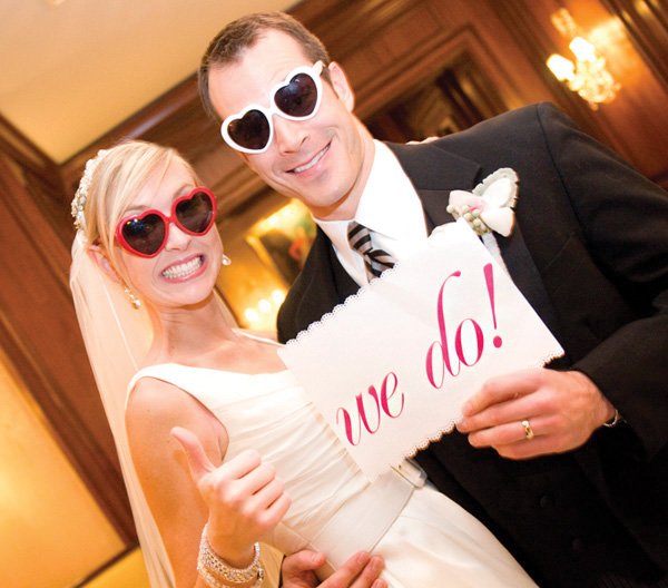 bride and groom after the ceremony holding a 'we do' sign