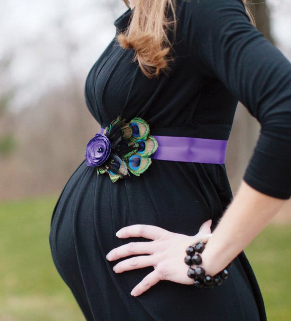 pregnant mother's belly photo with pretty peacock feather and ribbon belt