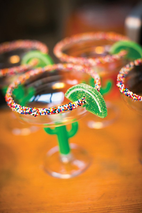 DIY candy margarita glasses with a sprinkled rim and gummy lime